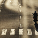 single motorcyclist in the middle of the crossroad at sunset